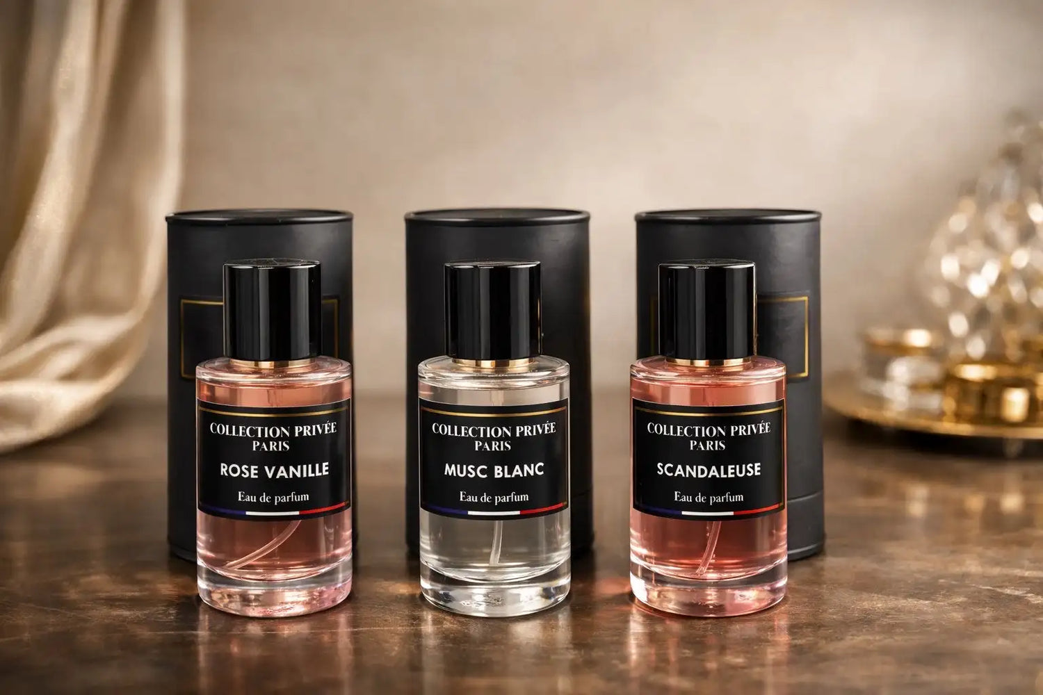 Trois flacons de parfum en verre de la collection Privée Paris, chacun avec un bouchon noir et une étiquette affichant le nom de son parfum.
